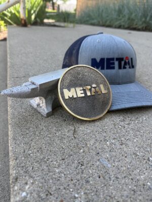 A METAL ball cap, medallion, and anvil.