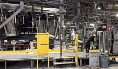 A worker moves cast iron bathtubs using a special machine.