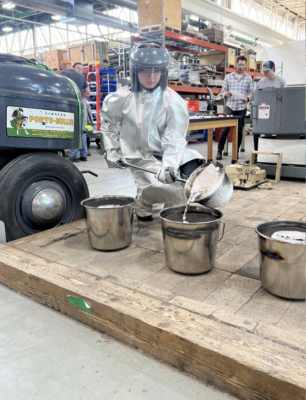 A bootcamp participant pours molten metal by hand.